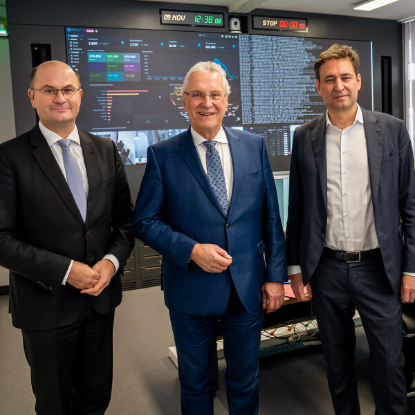 Innenminister Joachim Herrmann, Finanzminister Albert Füracker und Justizminister Georg Eisenreich im Cyber-Lagezentrum, im Hintergrund Arbeitsplätze mit vielen Monitoren