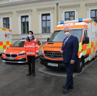 Innenminister Joachim Herrmann und Rettungssanitäter vor Rettungswägen