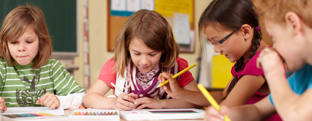 Vier Schulkinder in einem Klassenzimmer